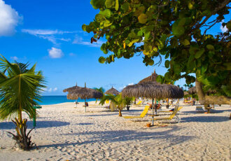 Beautiful beach with palapas and palmtrees, Eagle Beach, Aruba.